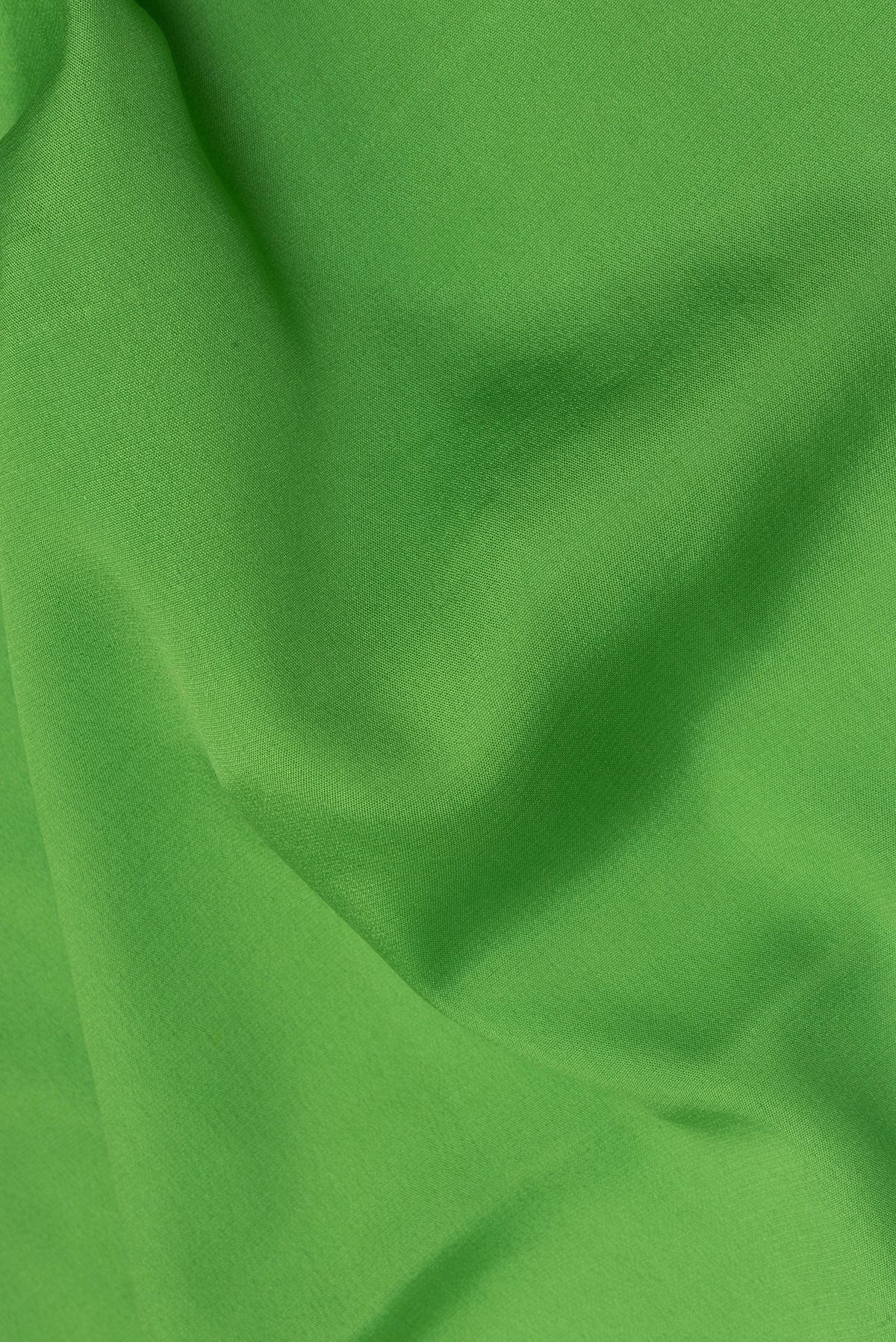 Close up of Parrot Green Mysore Crepe Saree with Plain Body and Zari Border.  displaying folds
