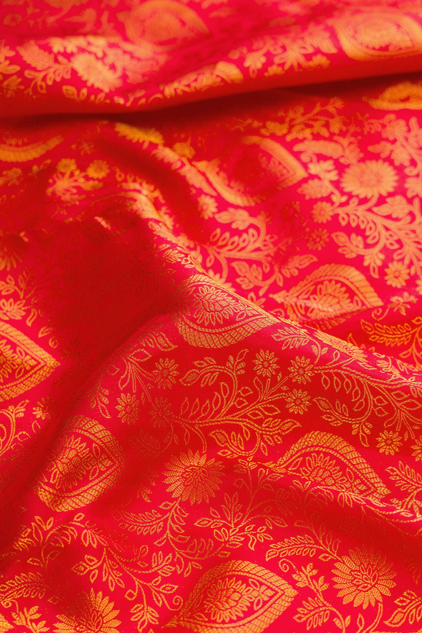 Close up of Red Dual Tone Kanjivaram Silk Saree with Zari Brocade on the body and Zari Border.  displaying folds