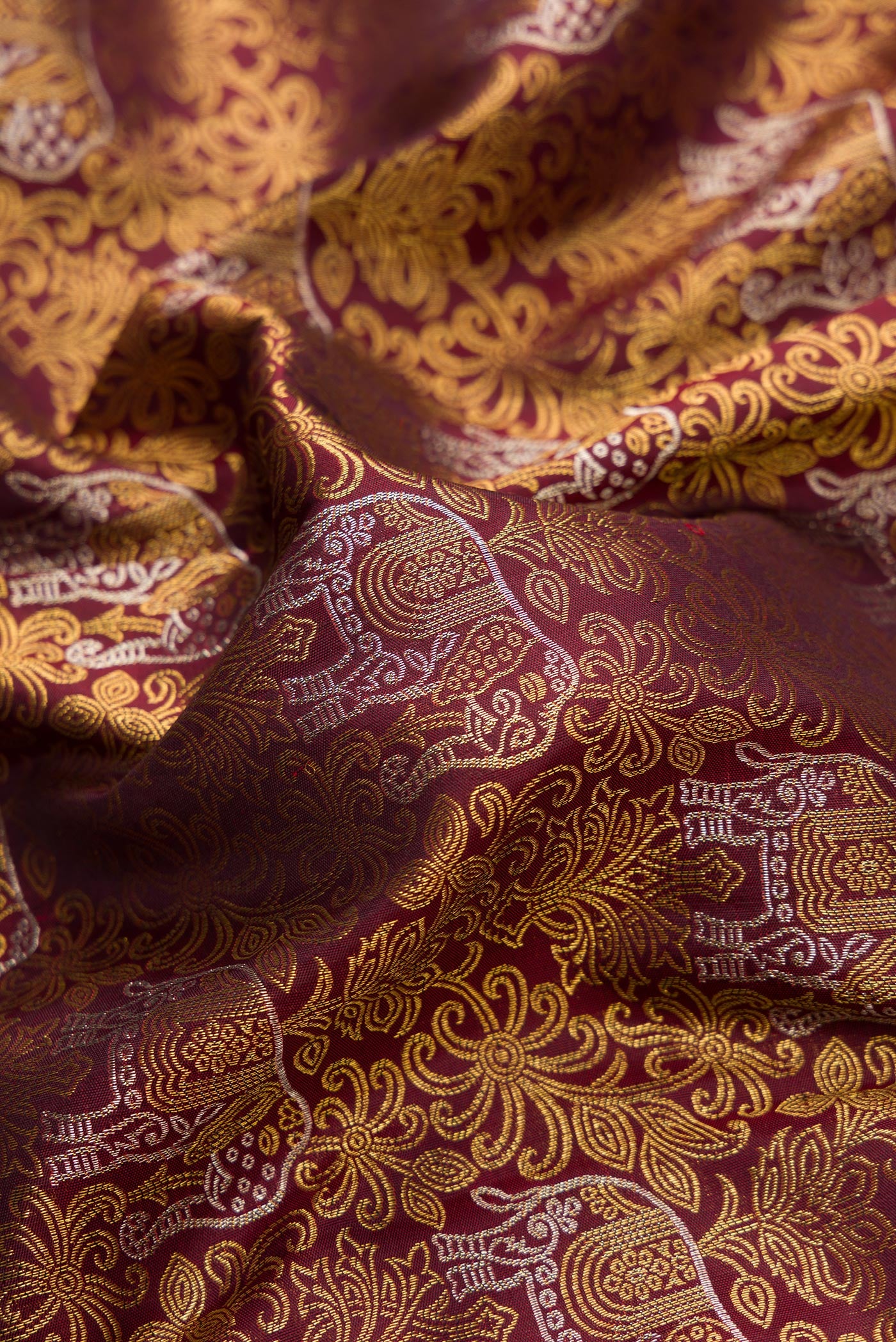 Close up of Maroon Dual Tone Kanchipuram Silk Saree with Zari Brocade on the body and Zari Border.  displaying folds