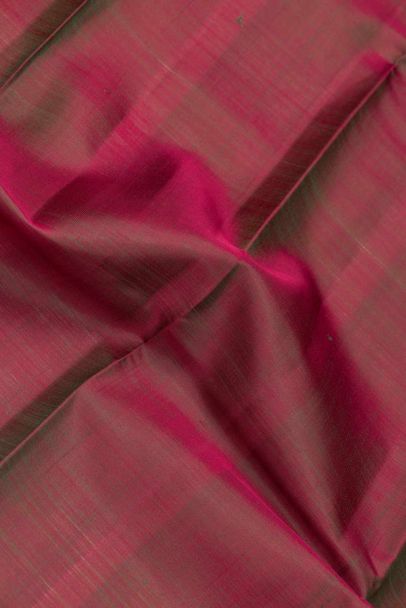 Close up of Mehandi Green Dual Tone Kanchipuram Saree with Plain Body and Zari Border.  displaying folds