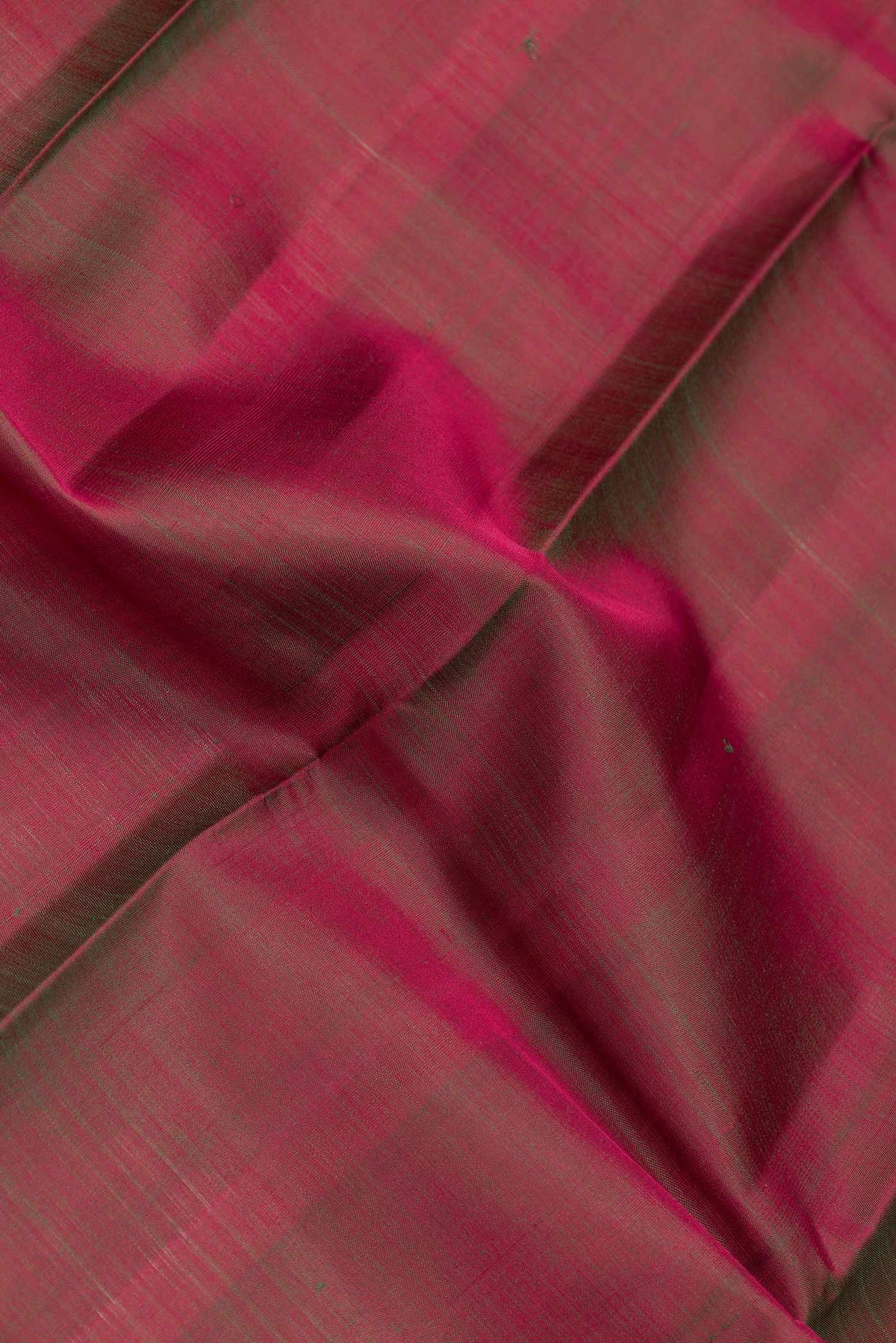 Close up of Mehandi Green Dual Tone Kanchipuram Saree with Plain Body and Zari Border.  displaying folds