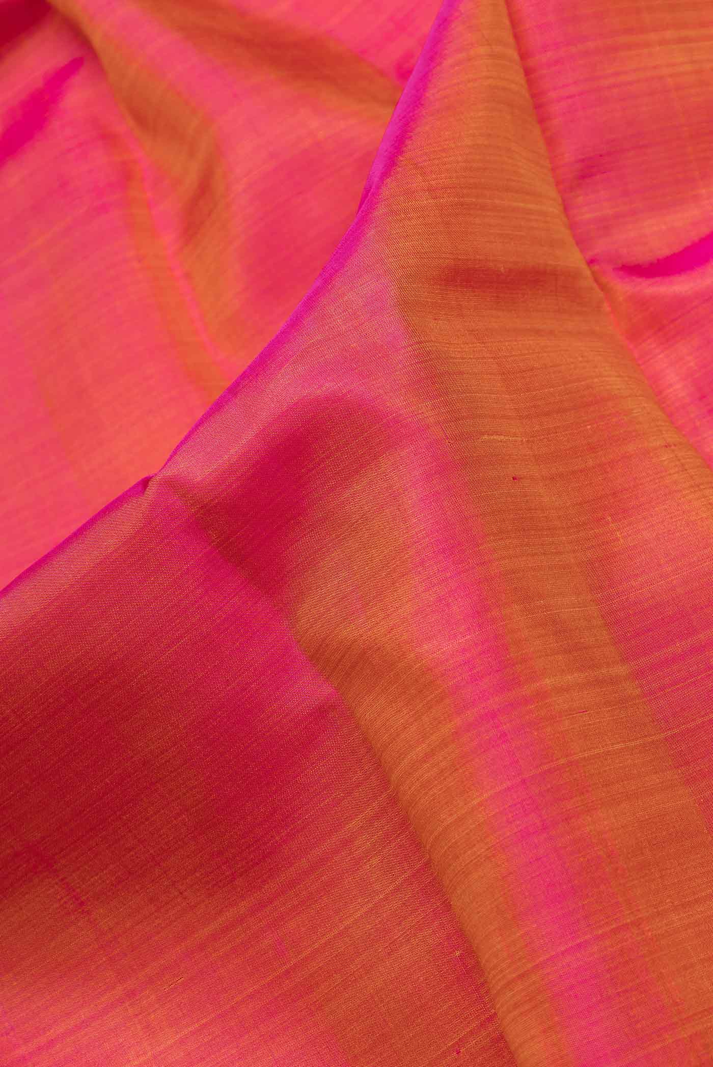 Close up of Pink Dual Tone Kanchipuram Saree with Plain Body and Zari Border.  displaying folds
