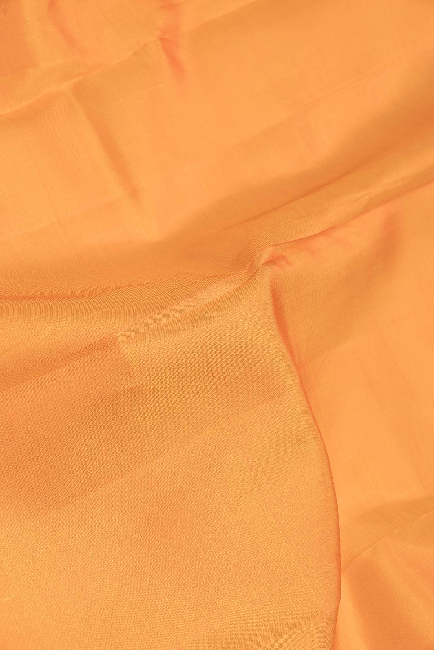 Close up of Yellow Dual Tone Kanchipuram Saree with Plain Body and Zari Border.  displaying folds