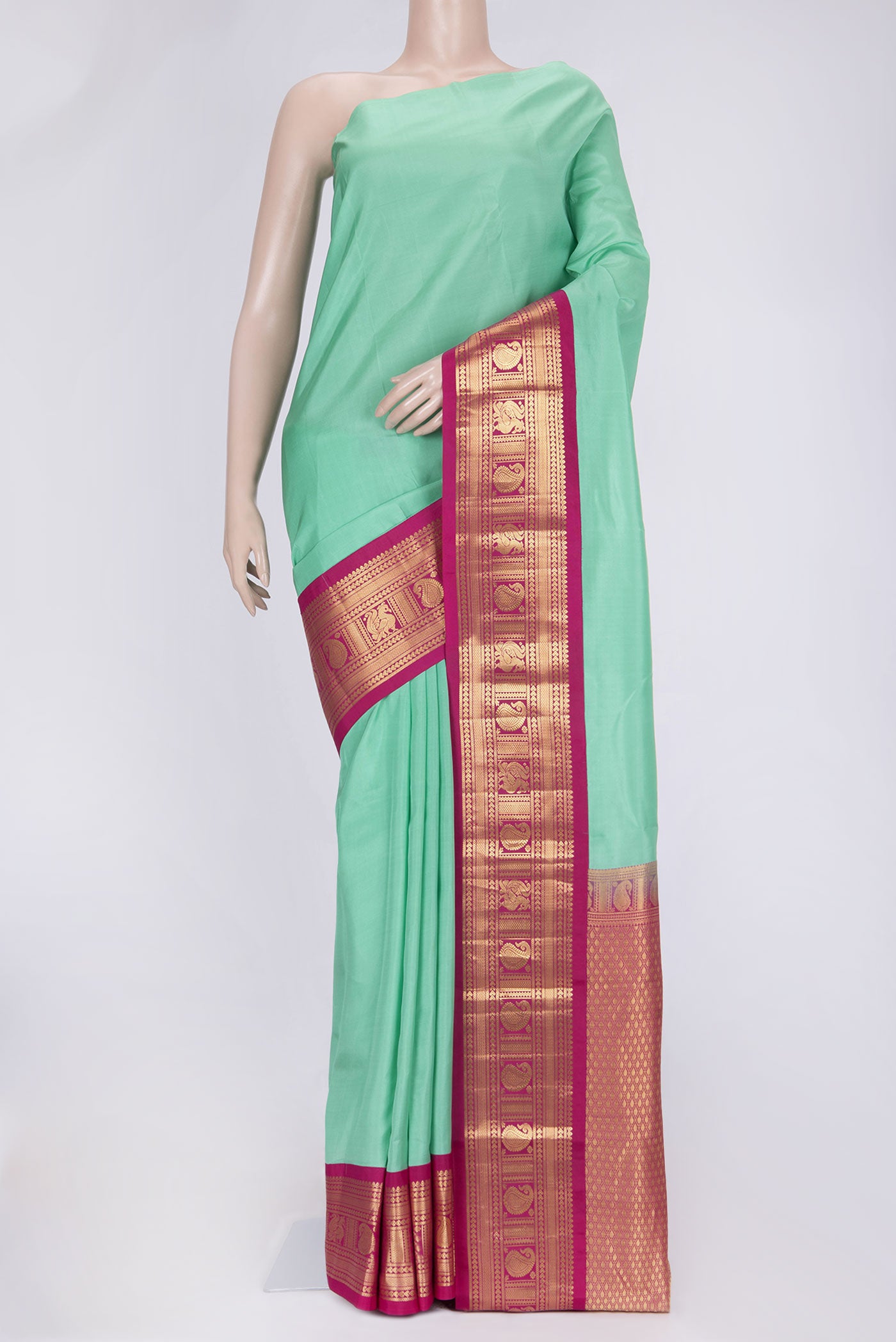 Pista Green Dual Tone Kanchipuram Saree with Plain Body and Zari Border.  displayed on a mannequin