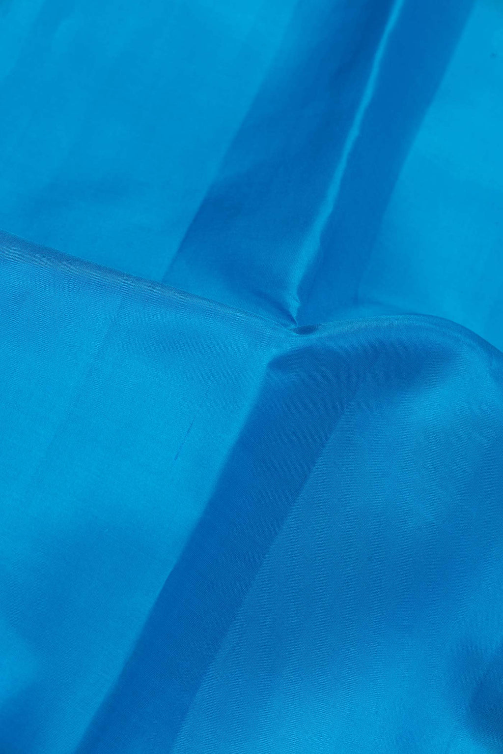 Close up of Peacock Blue Dual Tone Kanchipuram Saree with Plain Body and Zari Border.  displaying folds