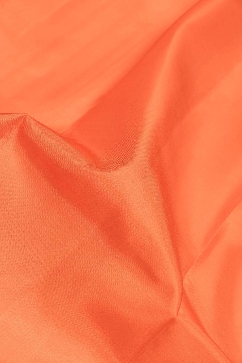 Close up of Orange Dual Tone Kanchipuram Saree with Plain Body and Zari Border.  displaying folds