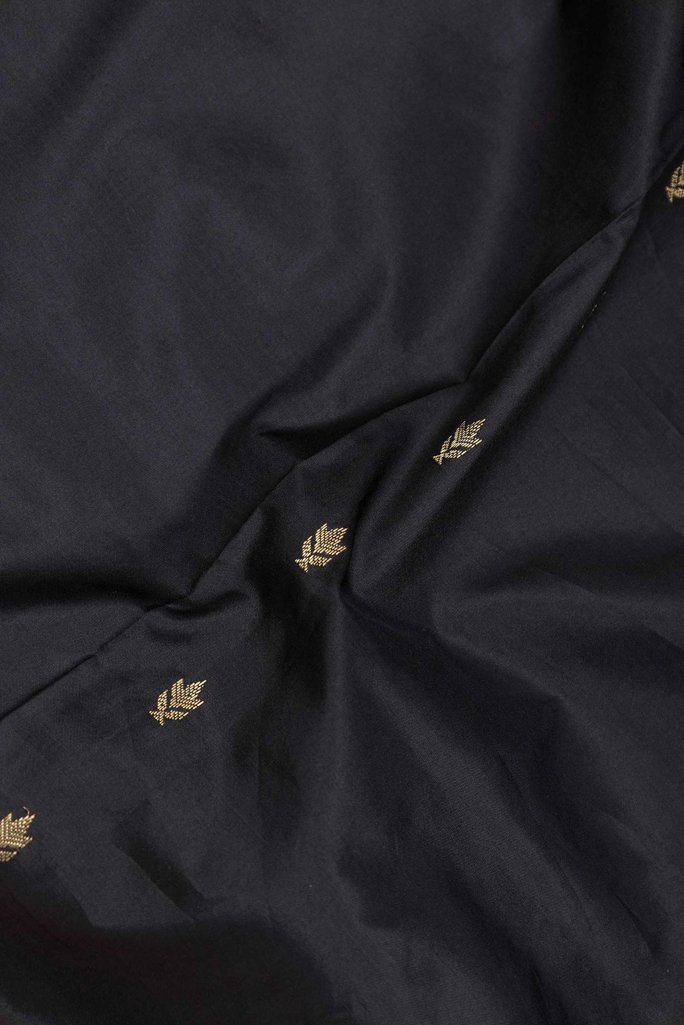 Close up of Black Bangalore Silk Saree with Zari Butta on the body and Zari Border displaying folds