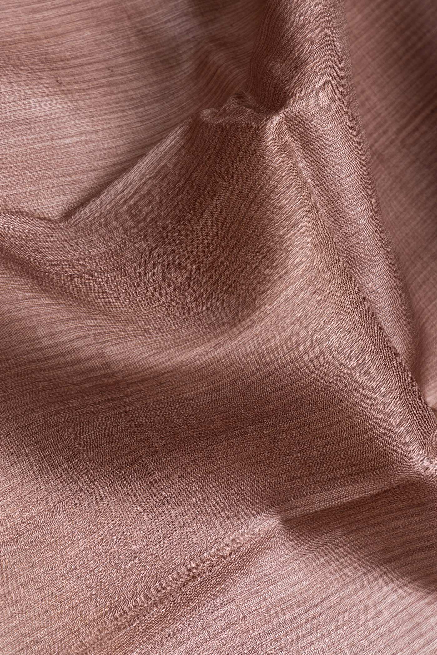 Close up of Brown Dual Tone Tussar Silk Saree with Printed design on the body and Fancy Border.  displaying folds