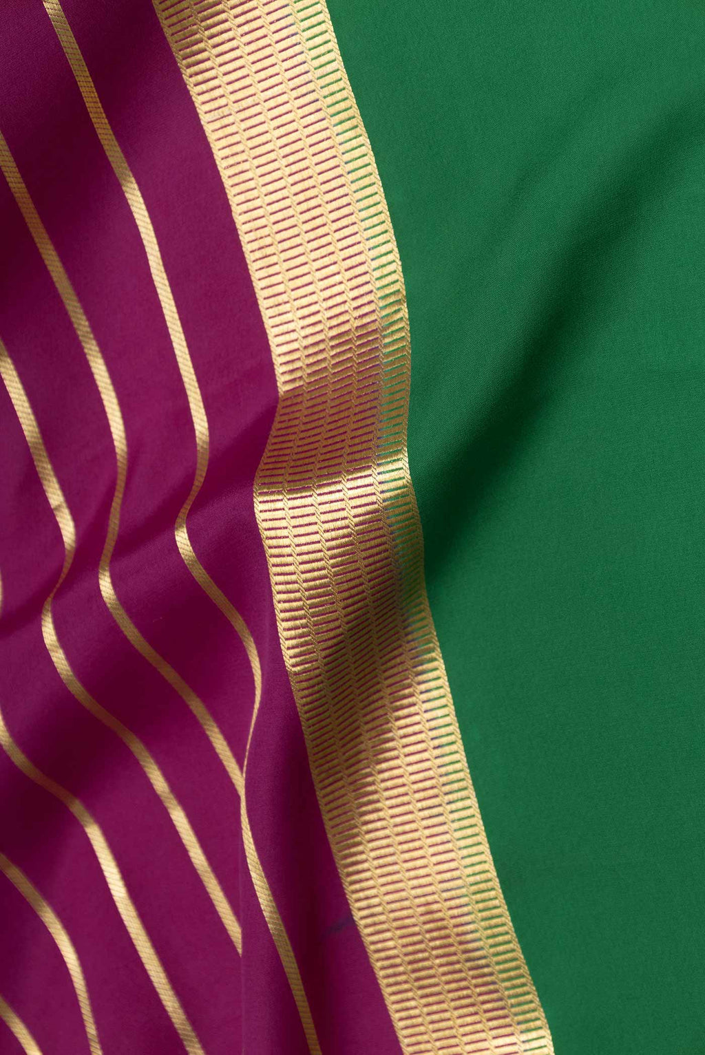 Close up of Magenta Dual Tone Mysore Crepe Saree with Stripes on the body and Zari Border displaying folds