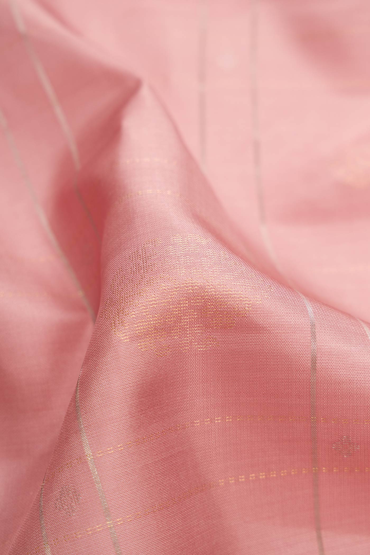 Close up of Rose Gold Dual Tone Soft Silk Saree with Checked design on the body and Without Border.  displaying folds