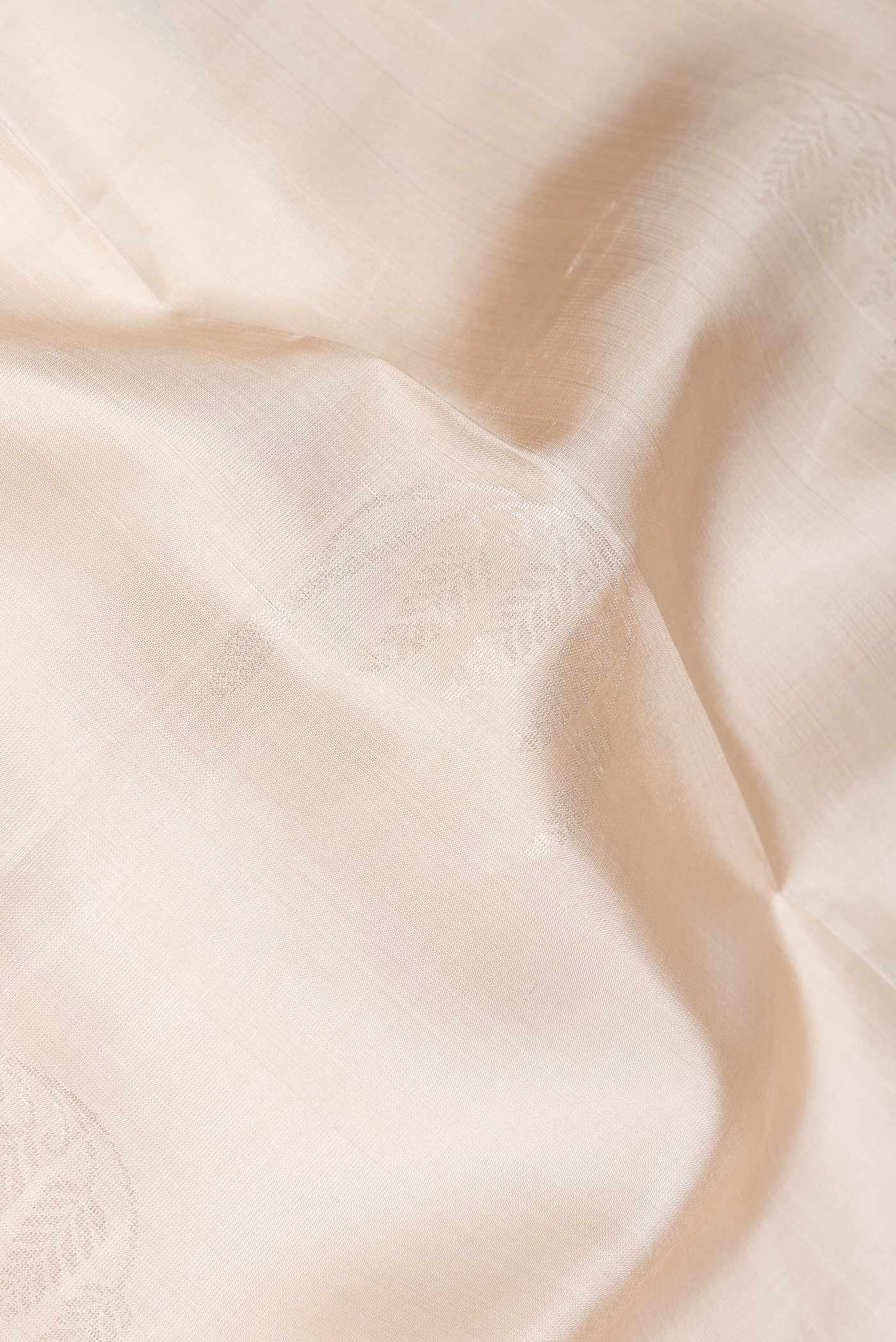 Close up of Beige Dual Tone Soft Silk Saree with Zari Butta on the body and Zari Border.  displaying folds