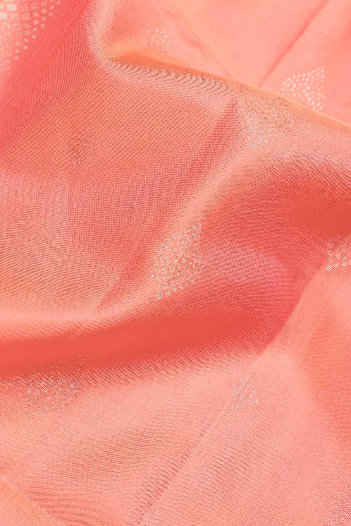 Close up of Peach Dual Tone Soft Silk Saree with Zari Butta on the body and Zari Border.  displaying folds