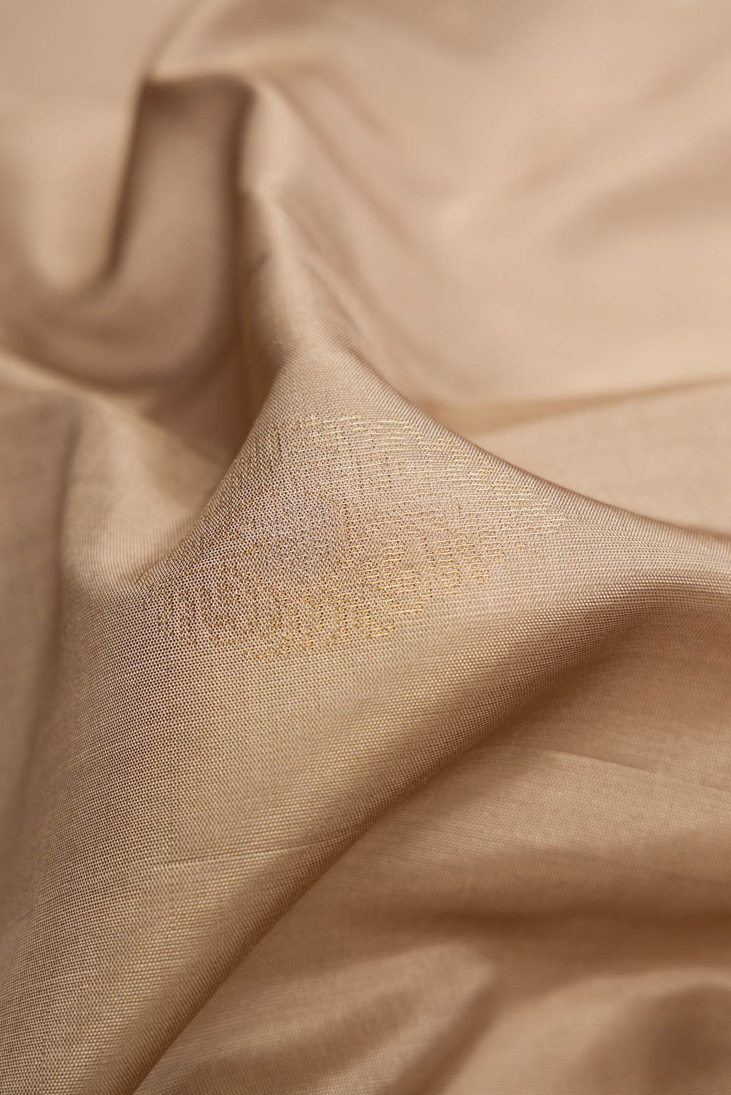 Close up of Beige Dual Tone Soft Silk Saree with Zari Butta on the body and Zari Border.  displaying folds