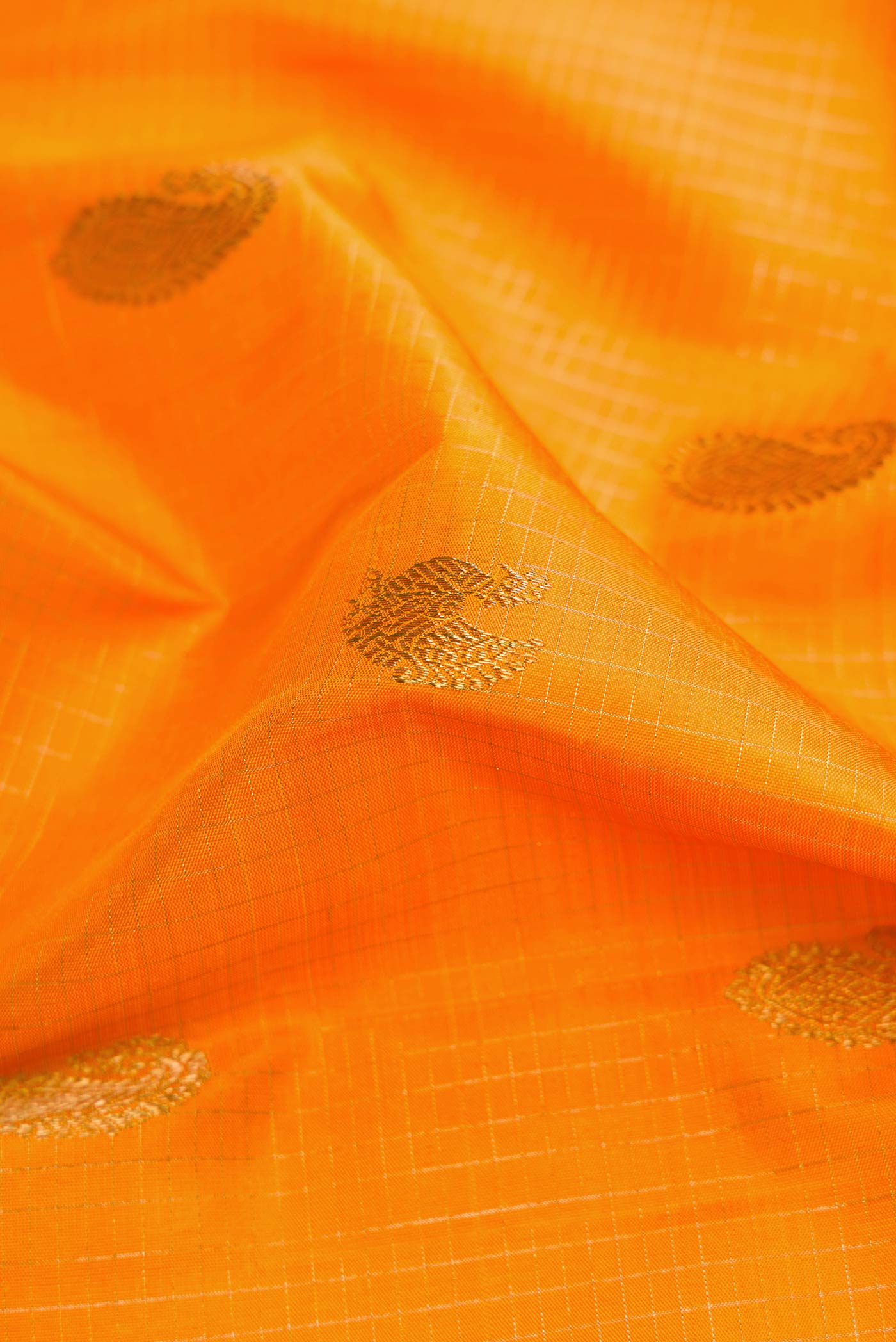 Close up of Pure Silk Pure Zari Yellow Kanchipuram Saree with Checked design on the body and Zari Border displaying folds