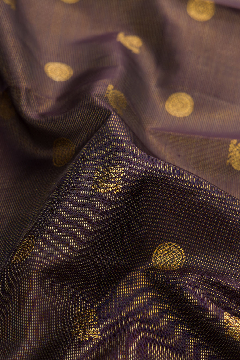Close up of Pure Silk Pure Zari Brown Dual Tone Kanchipuram Saree with Zari Butta on the body and Zari Border.  displaying folds