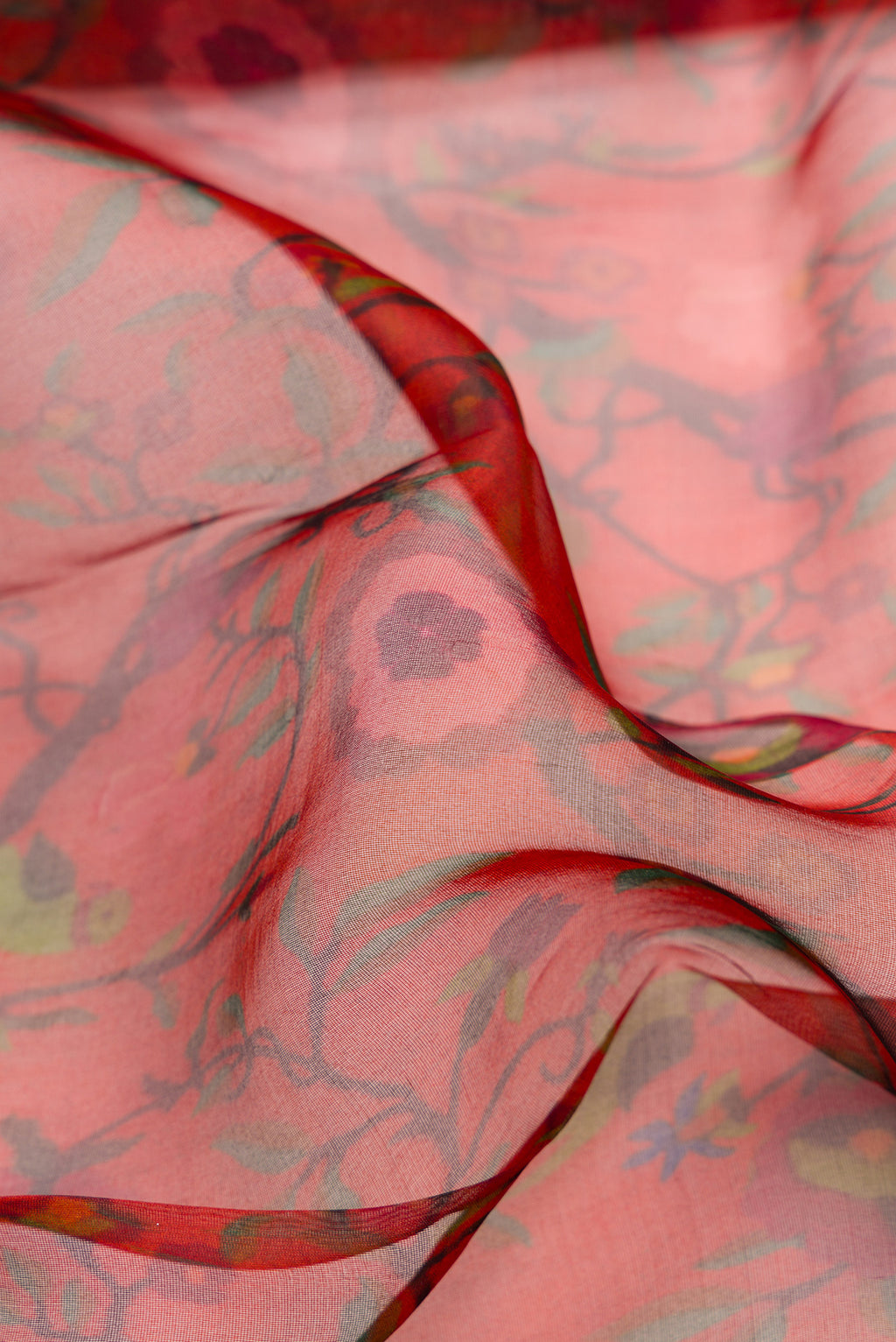 Close up of Maroon Dual Tone Organza Silk Saree with Printed design on the body and Zari Border.  displaying folds