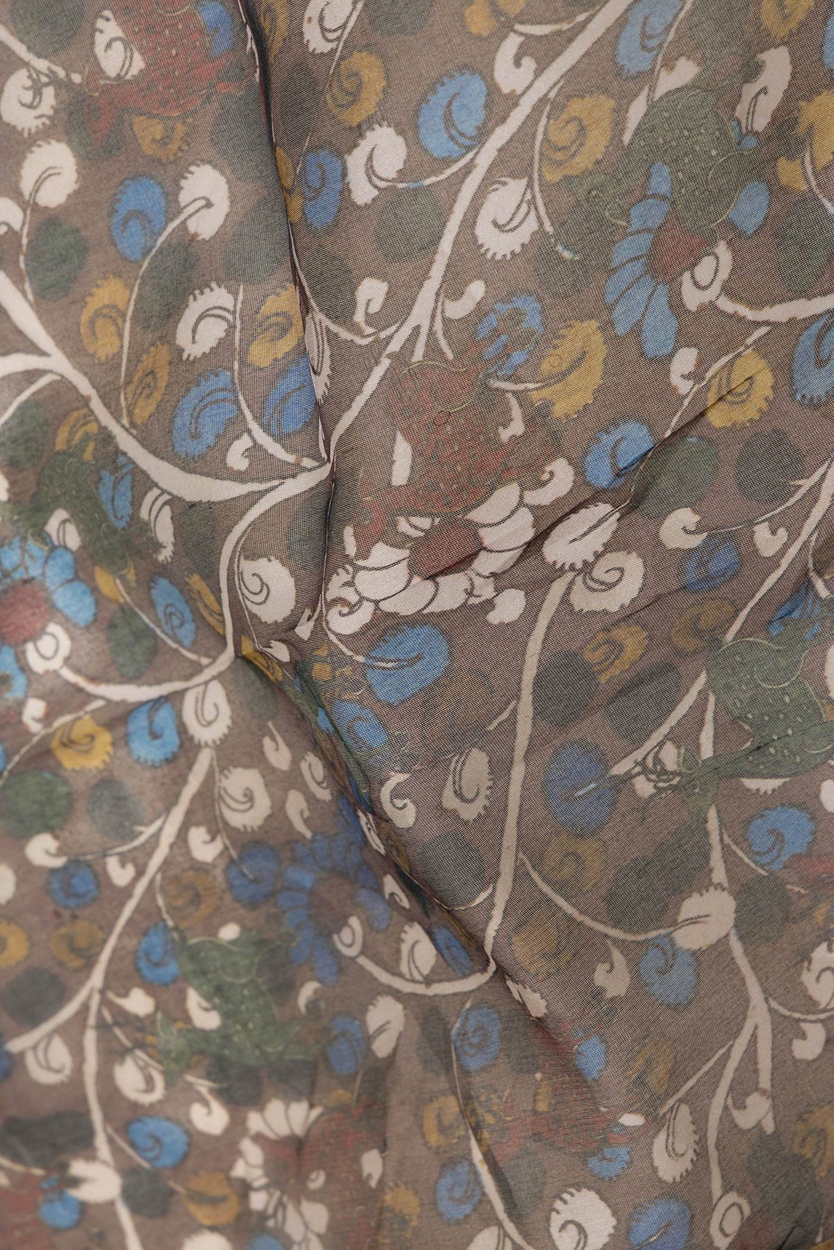 Close up of Brown Dual Tone Organza Silk Saree with Printed design on the body and Zari Border.  displaying folds