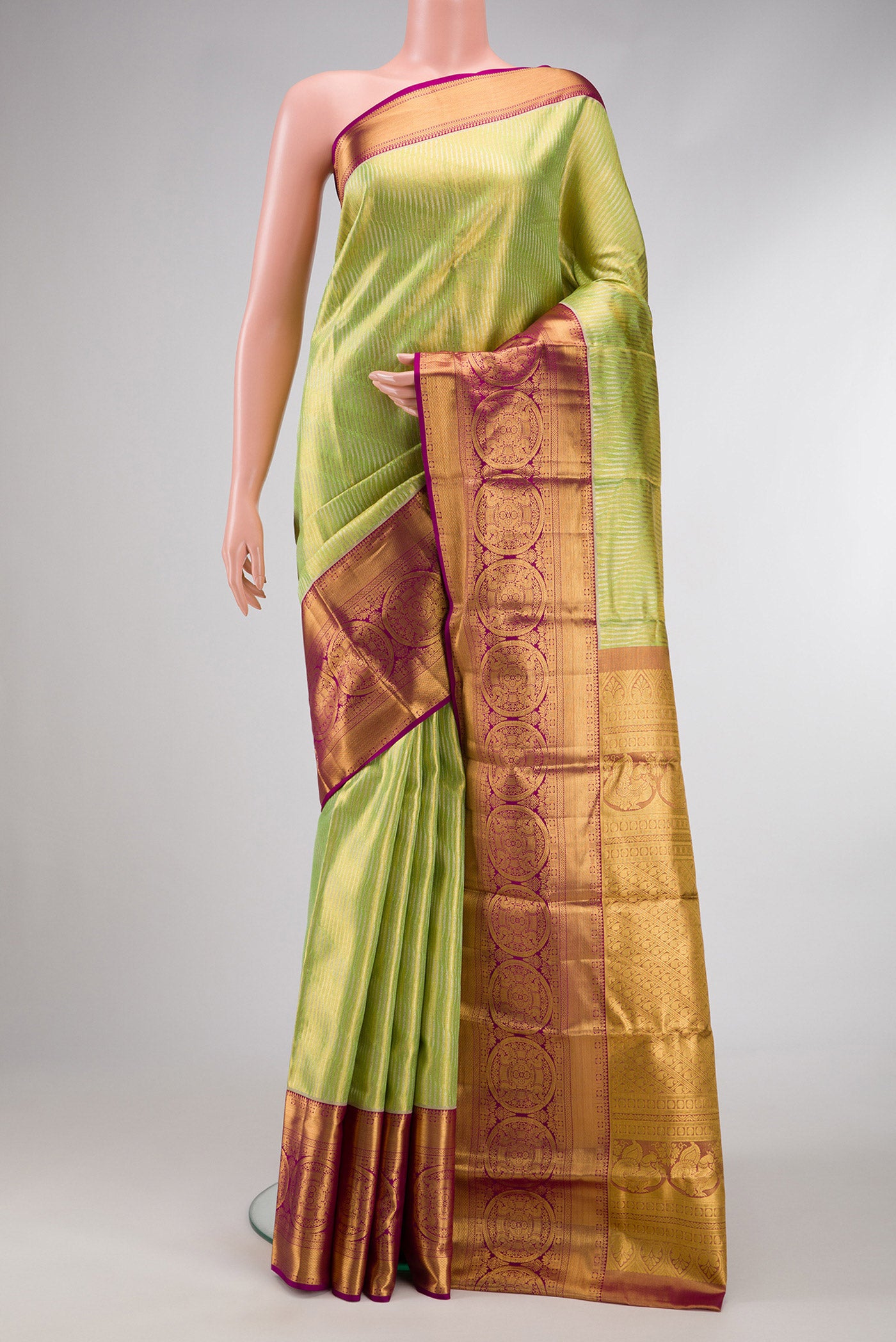 Parrot Green Dual Tone Kanjivaram Tissue Silk Saree with Zari Brocade on the body and Zari Border.  displayed on a mannequin