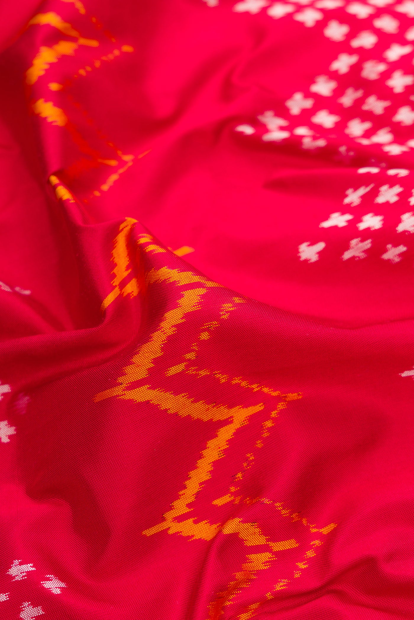 Close up of Red Dual Tone Double Ikat Saree with Ikat Print on the body and Ikat Border.  displaying folds