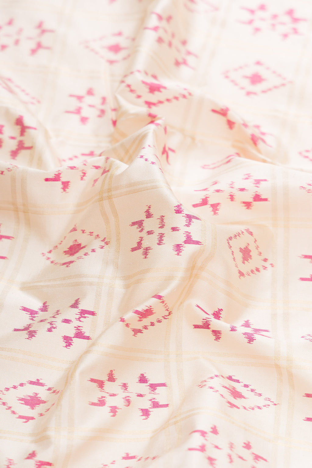 Close up of Off White Dual Tone Double Ikat Saree with Ikat Print on the body and Zari Border.  displaying folds