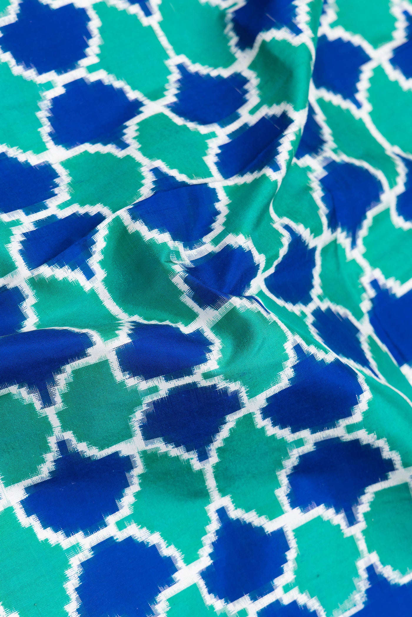 Close up of Sea Green Dual Tone Double Ikat Saree with Ikat Print on the body and Plain Border.  displaying folds