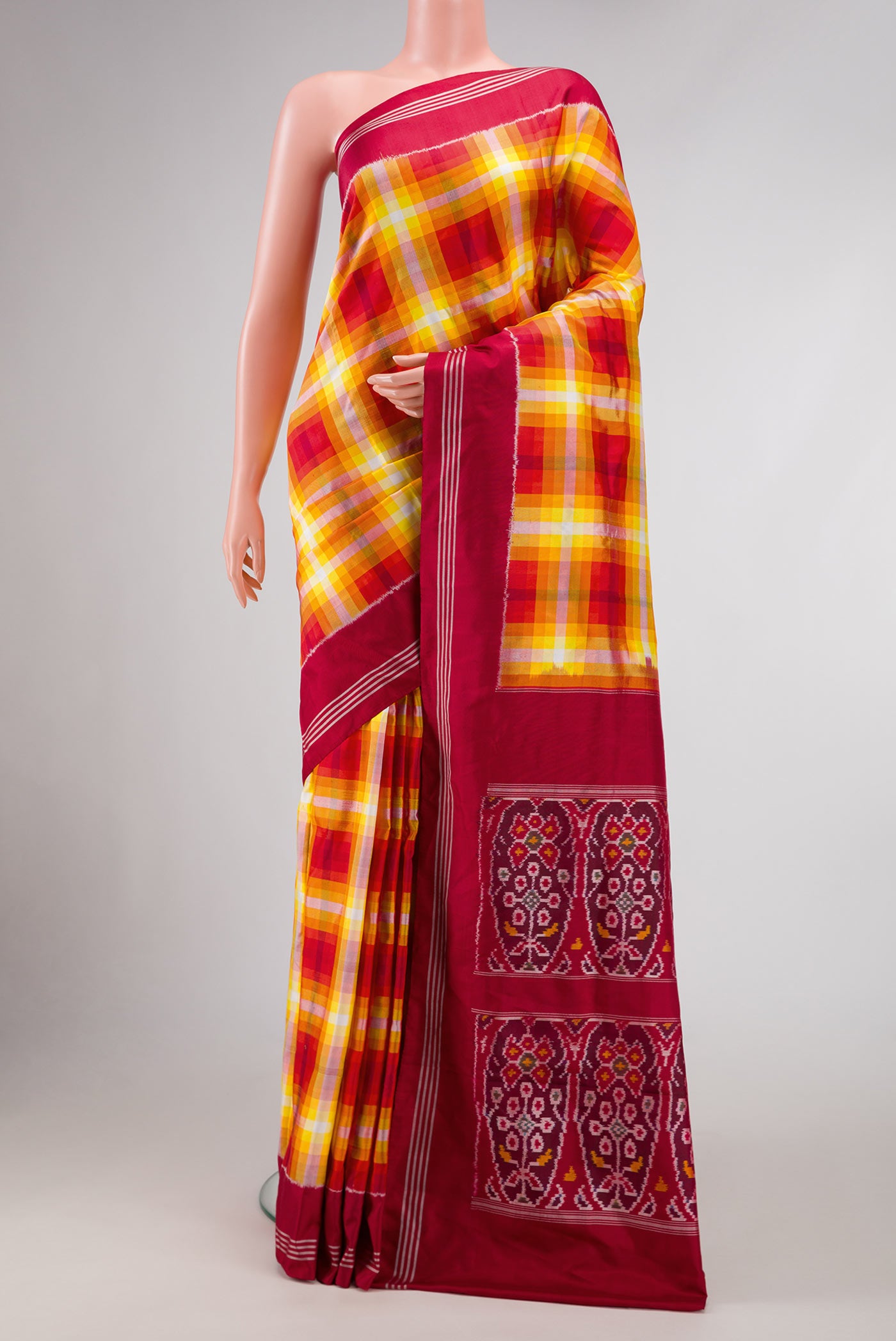 Mustard Dual Tone Double Ikat Saree with Checked design on the body and Zari Border.  displayed on a mannequin