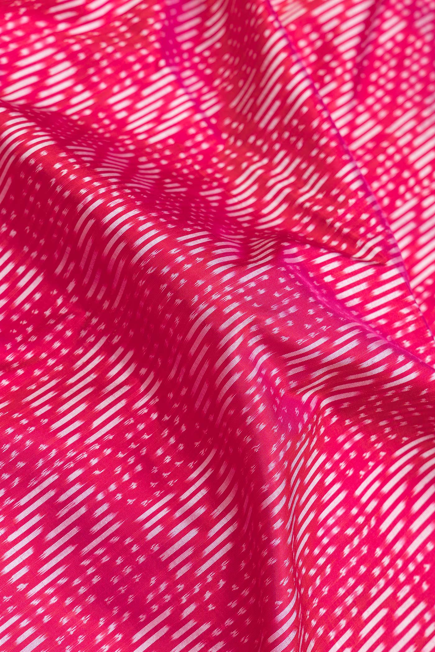 Close up of Pink Dual Tone Double Ikat Saree with Ikat Print on the body and Zari Border.  displaying folds