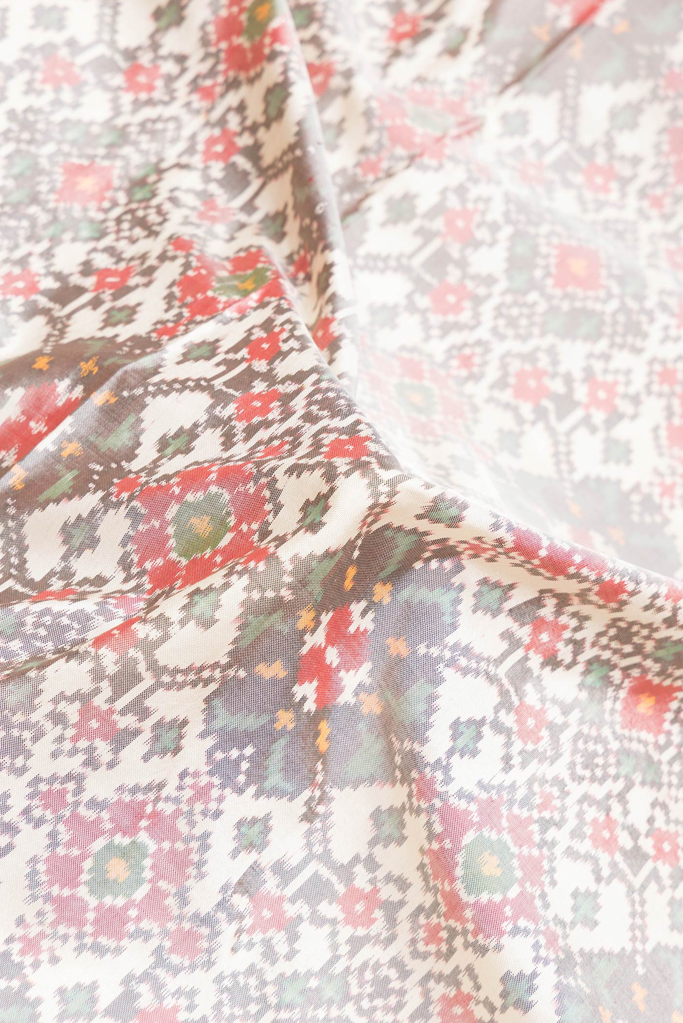 Close up of Grey Dual Tone Double Ikat Saree with Ikat Print on the body and Ikat Border.  displaying folds