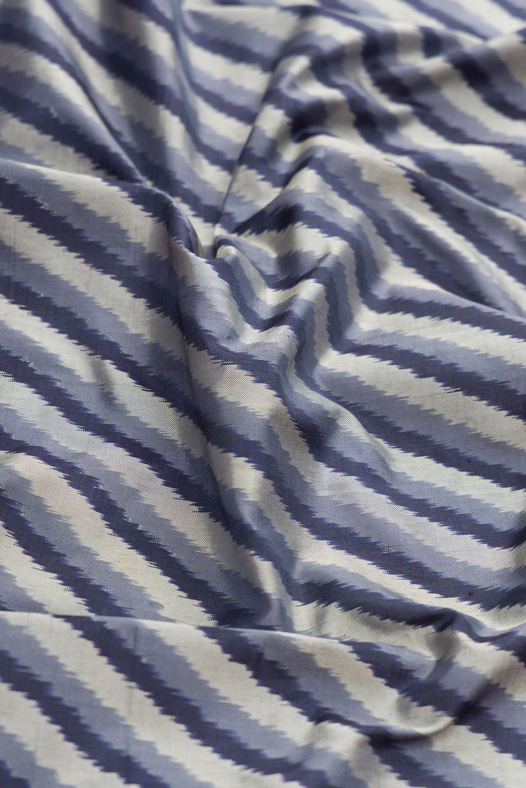 Close up of Grey Dual Tone Double Ikat Saree with Ikat Print on the body and Ikat Border.  displaying folds