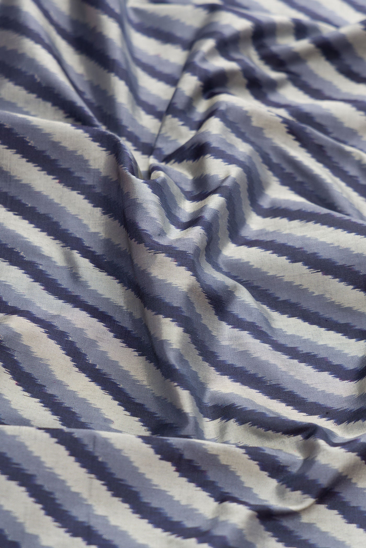 Close up of Grey Dual Tone Double Ikat Saree with Ikat Print on the body and Ikat Border.  displaying folds