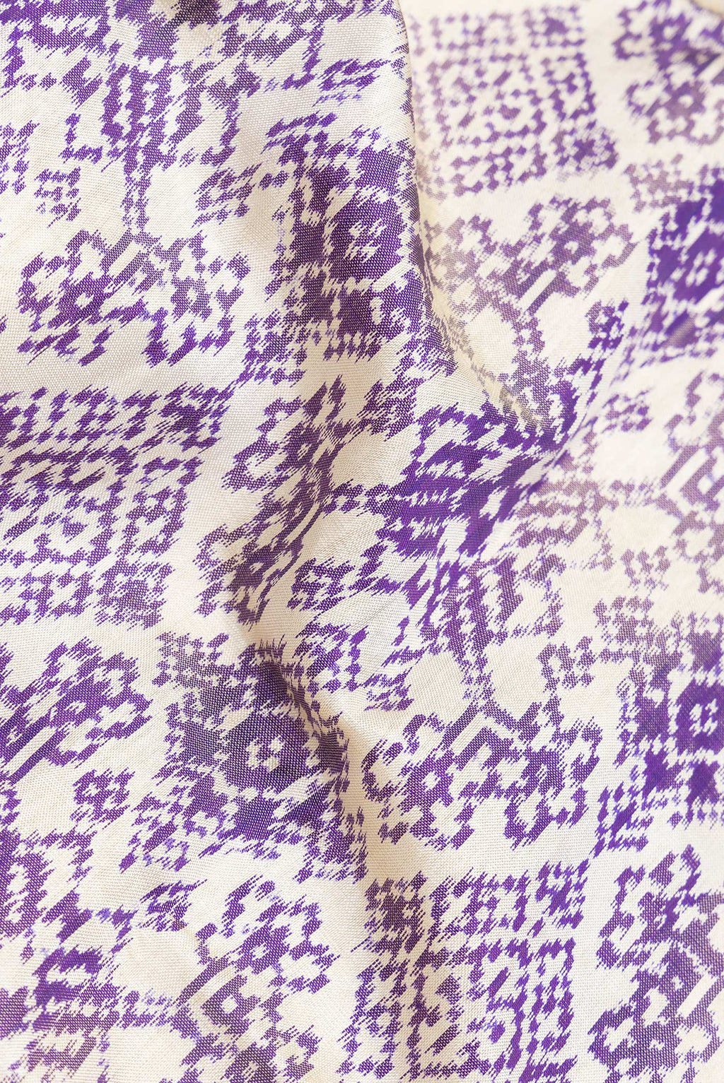 Close up of Off White Dual Tone Double Ikat Saree with Ikat Print on the body and Ikat Border.  displaying folds