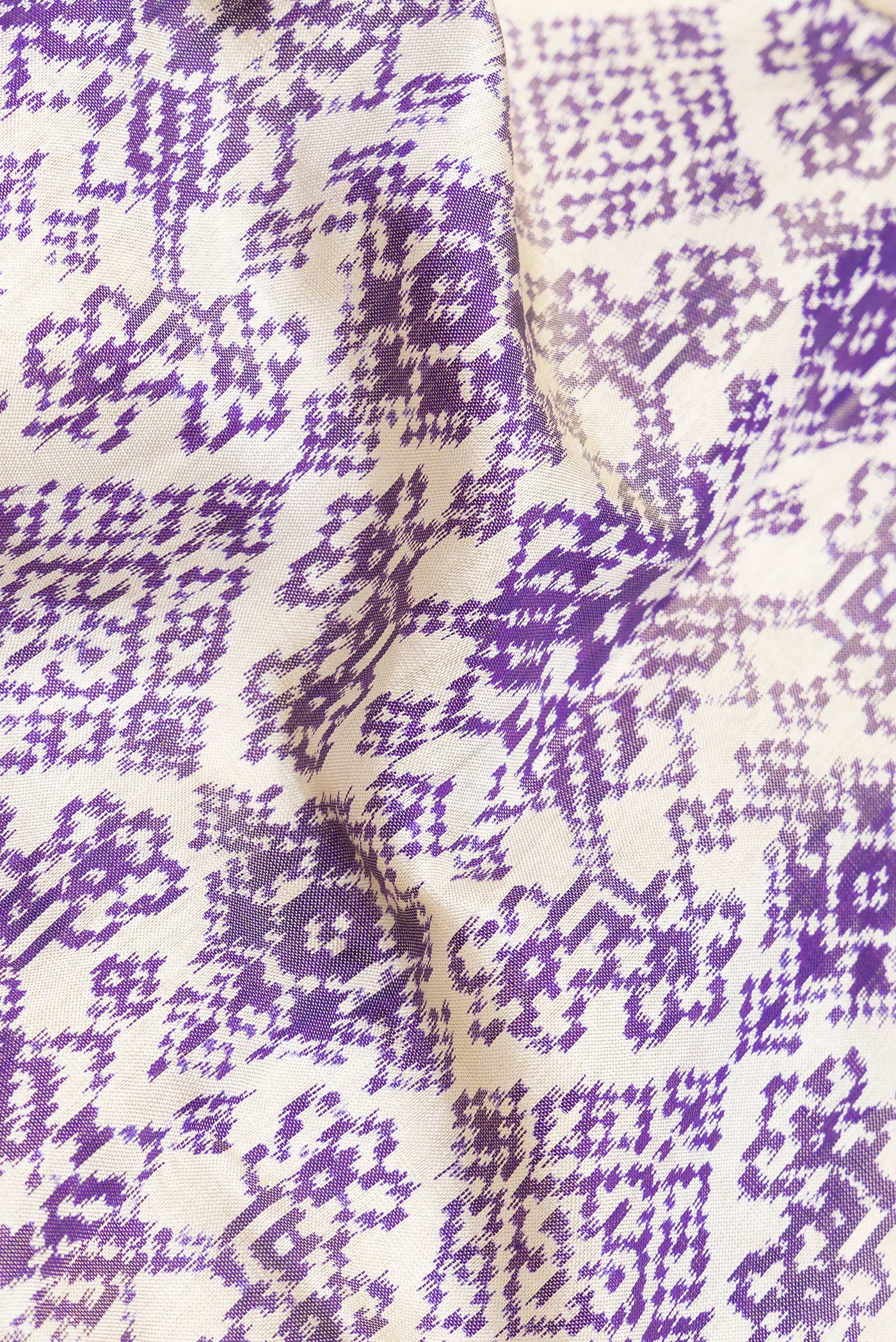 Close up of Off White Dual Tone Double Ikat Saree with Ikat Print on the body and Ikat Border.  displaying folds