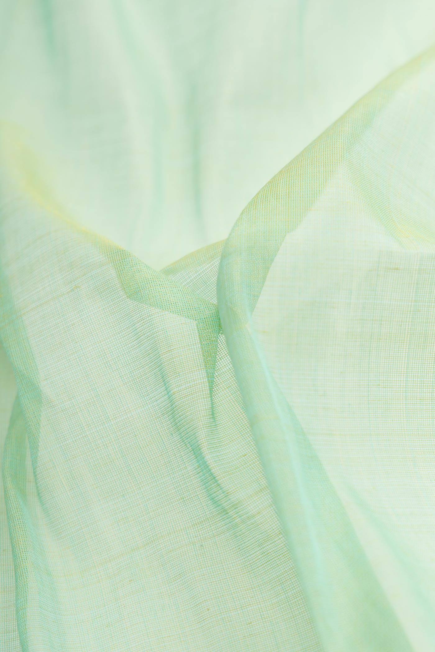 Close up of Pista Green Dual Tone Uppada Silk Saree with Plain Body and Thread Border.  displaying folds