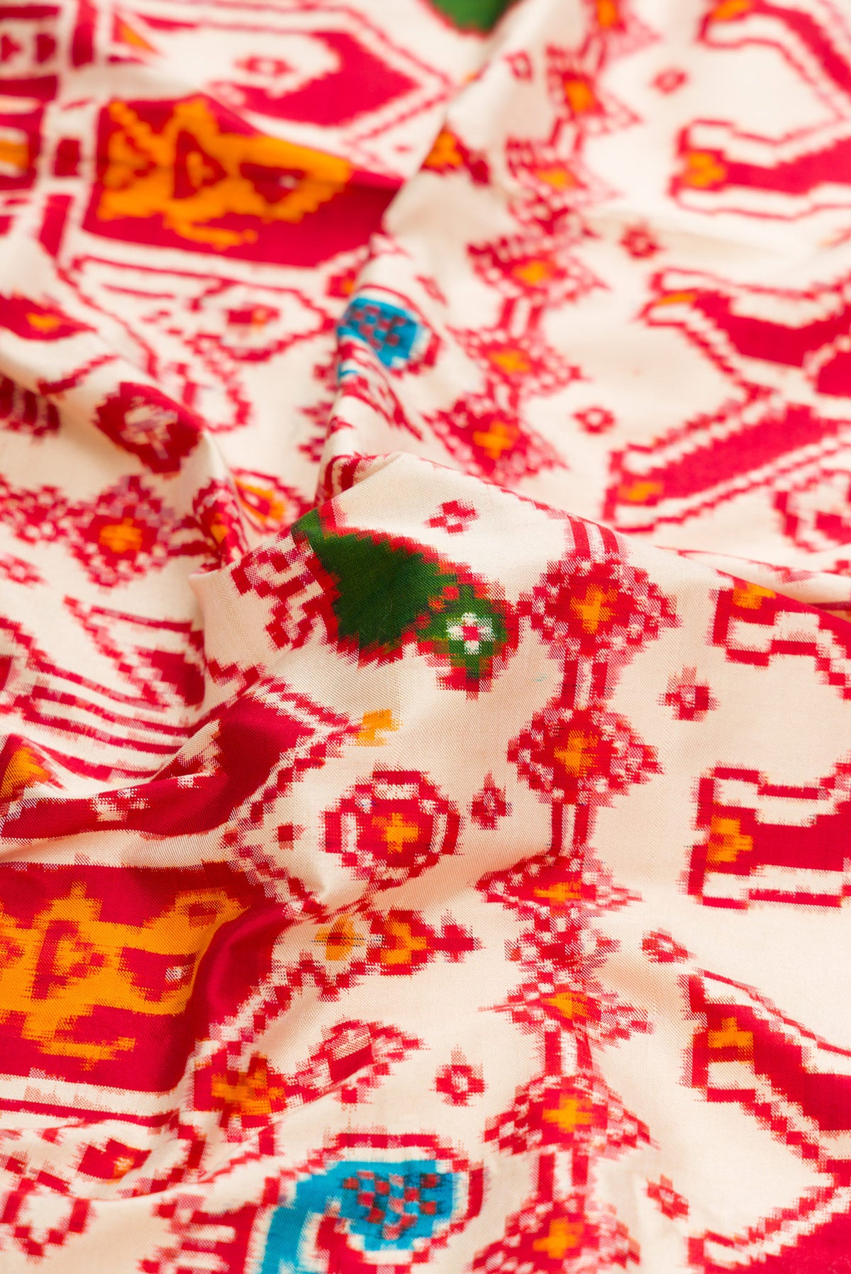 Close up of Sandal Dual Tone Double Ikat Saree with Ikat Print on the body and Plain Border.  displaying folds