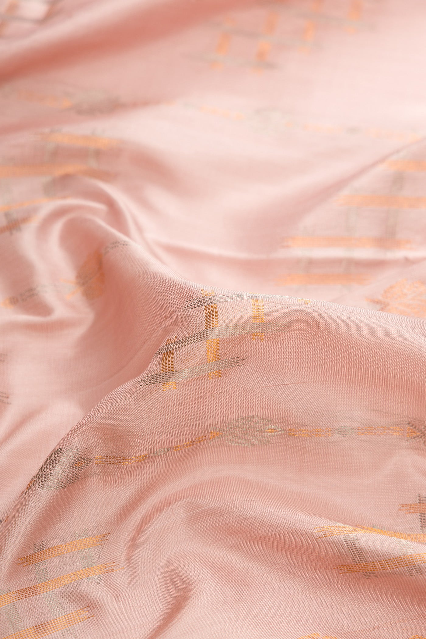 Close up of Rose Gold Dual Tone Uppada Silk Saree with Zari Butta on the body and Zari Border.  displaying folds