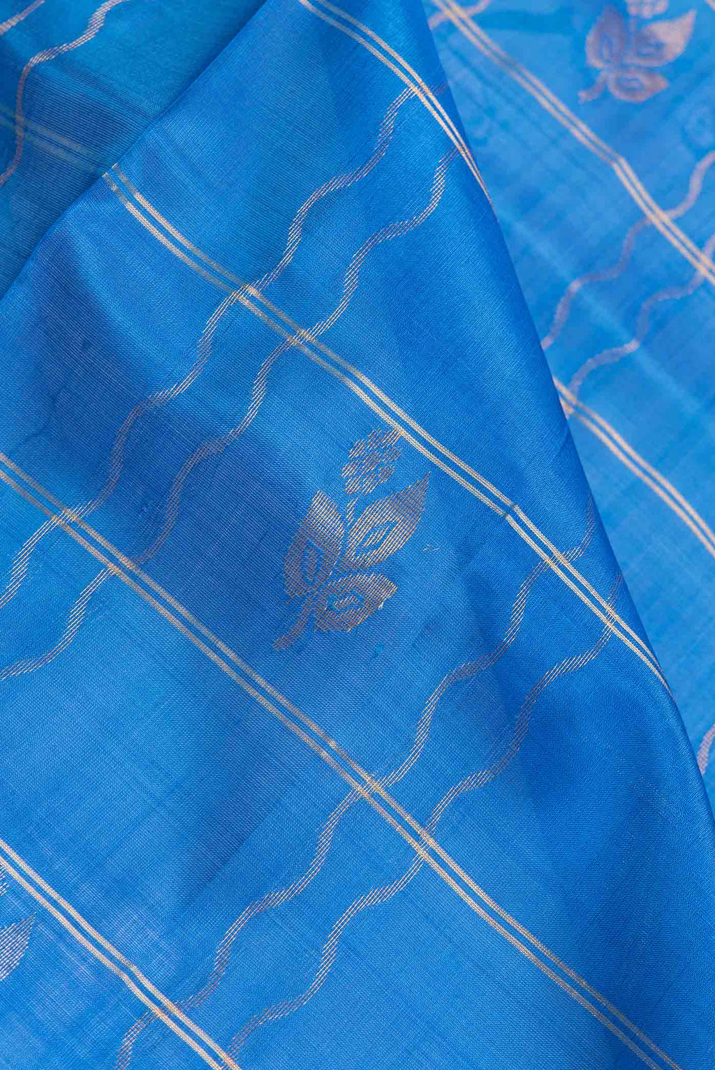 Close up of Royal Blue Dual Tone Uppada Silk Saree with Checked design on the body and Zari Border.  displaying folds