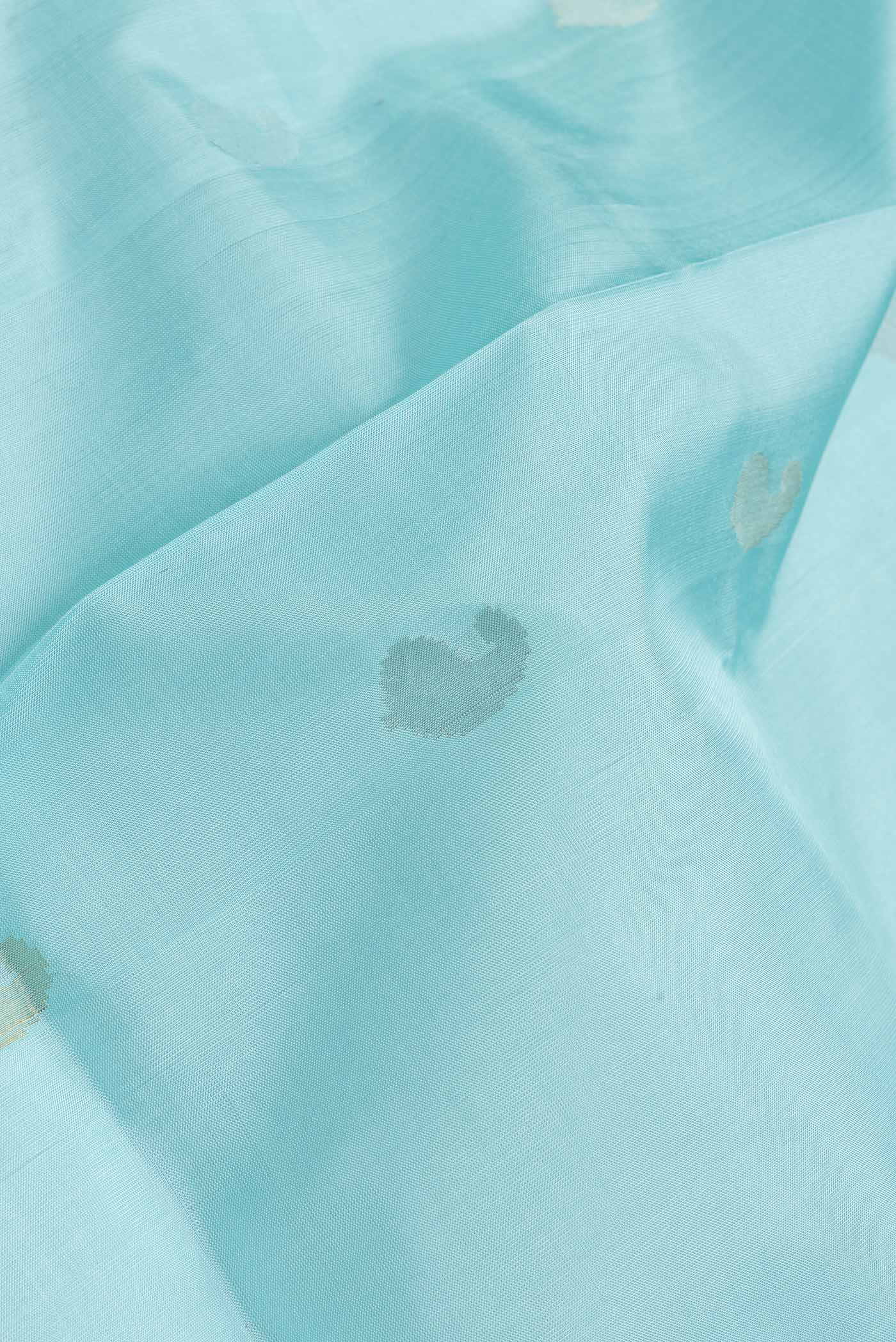 Close up of Sky Blue Dual Tone Uppada Silk Saree with Zari Butta on the body and Zari Border.  displaying folds