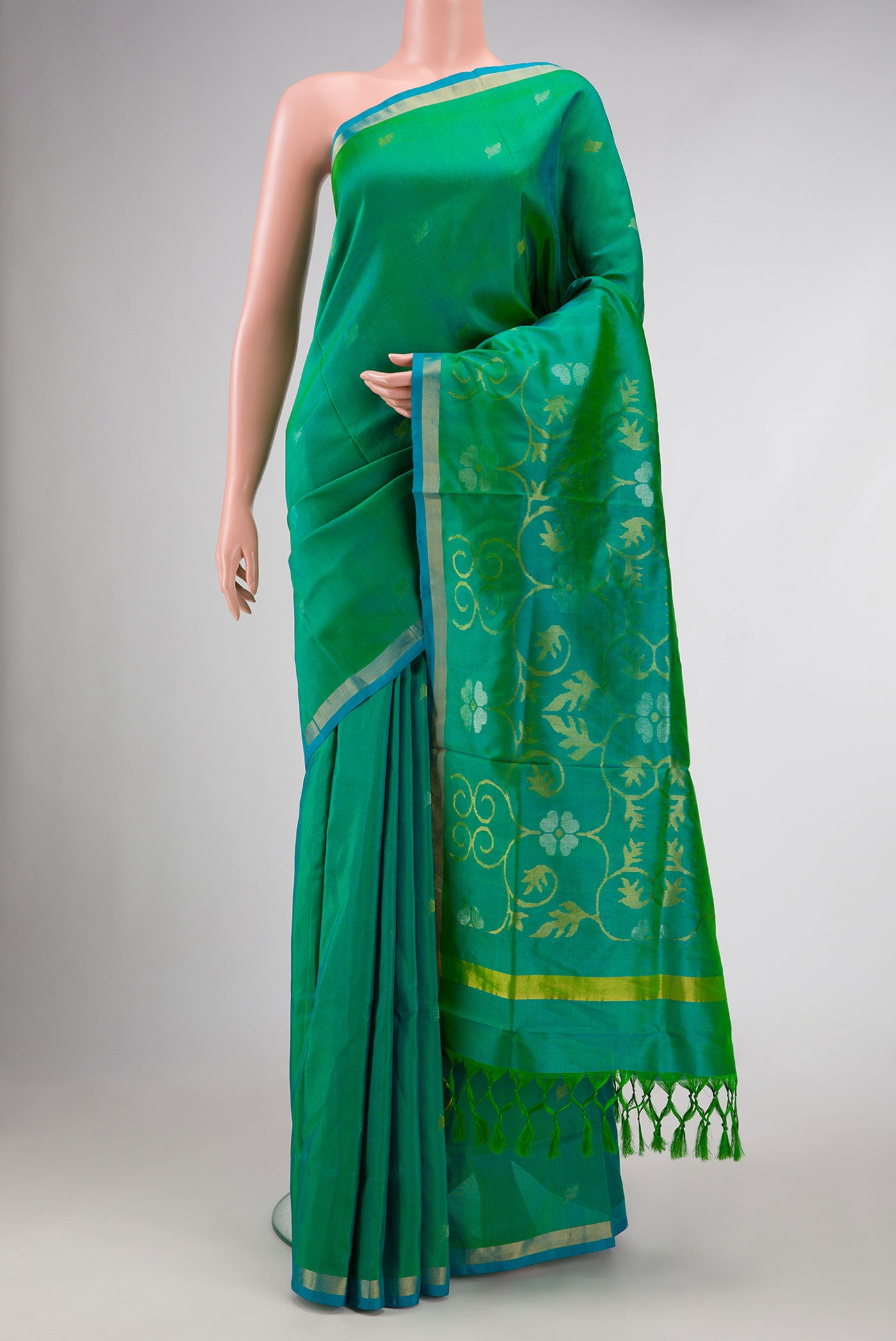 Green Dual Tone Uppada Silk Saree with Zari Butta on the body and Zari Border.  displayed on a mannequin