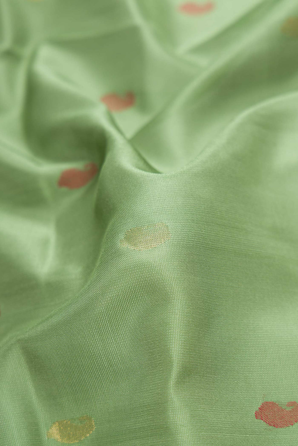 Close up of Green Dual Tone Uppada Silk Saree with Zari And Thread Butta on the body and Zari Border.  displaying folds