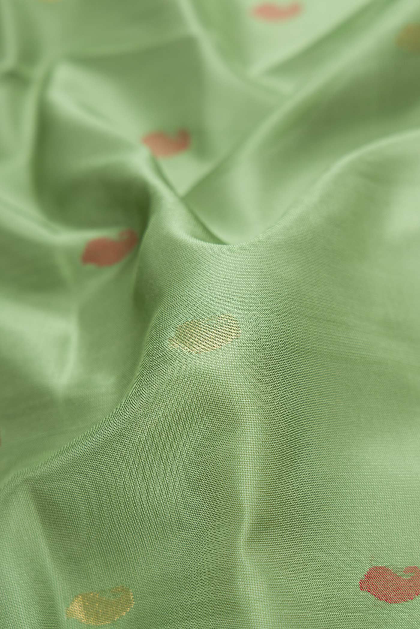 Close up of Green Dual Tone Uppada Silk Saree with Zari And Thread Butta on the body and Zari Border.  displaying folds
