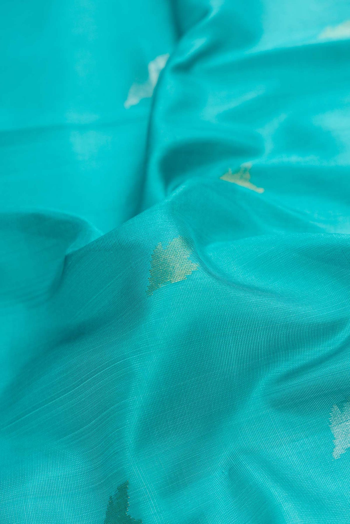 Close up of Sky Blue Dual Tone Uppada Silk Saree with Zari Butta on the body and Zari Border.  displaying folds