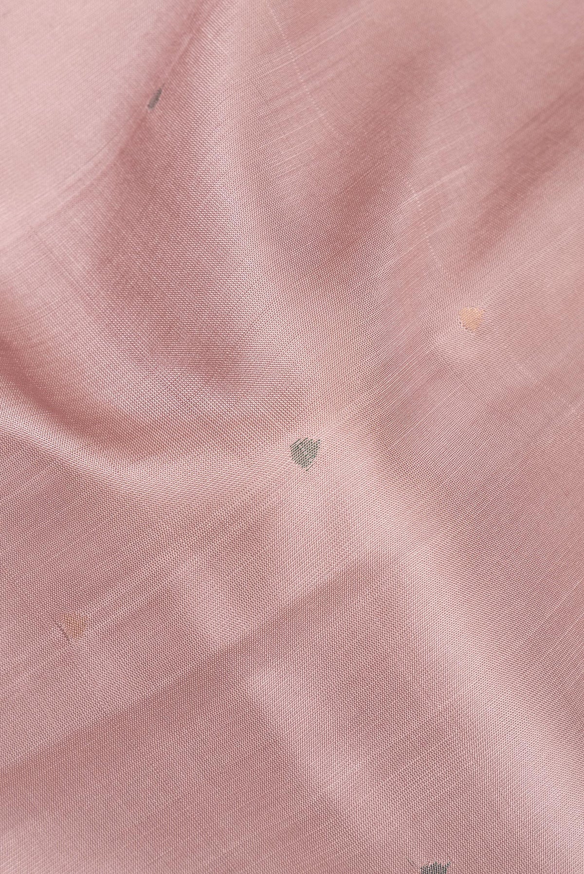 Close up of Pure Silk Rose Gold Uppada Saree with Zari And Thread Butta on the body and Zari Border.  displaying folds