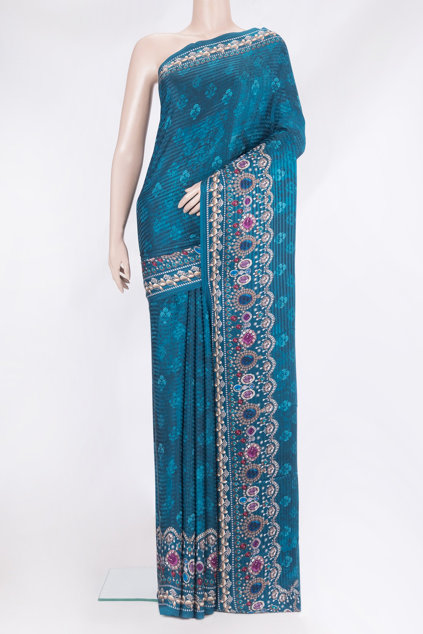 Peacock Blue Crepe Saree with Printed design on the body and Printed Border.  displayed on a mannequin
