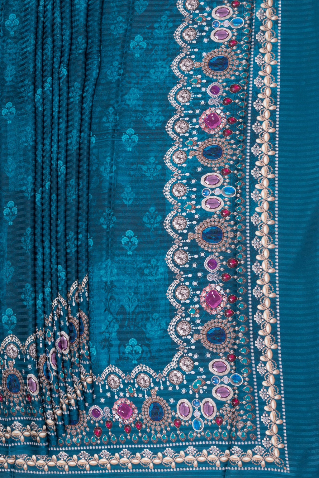 Pleats and pallu of Peacock Blue Crepe Saree with Printed design on the body and Printed Border. 