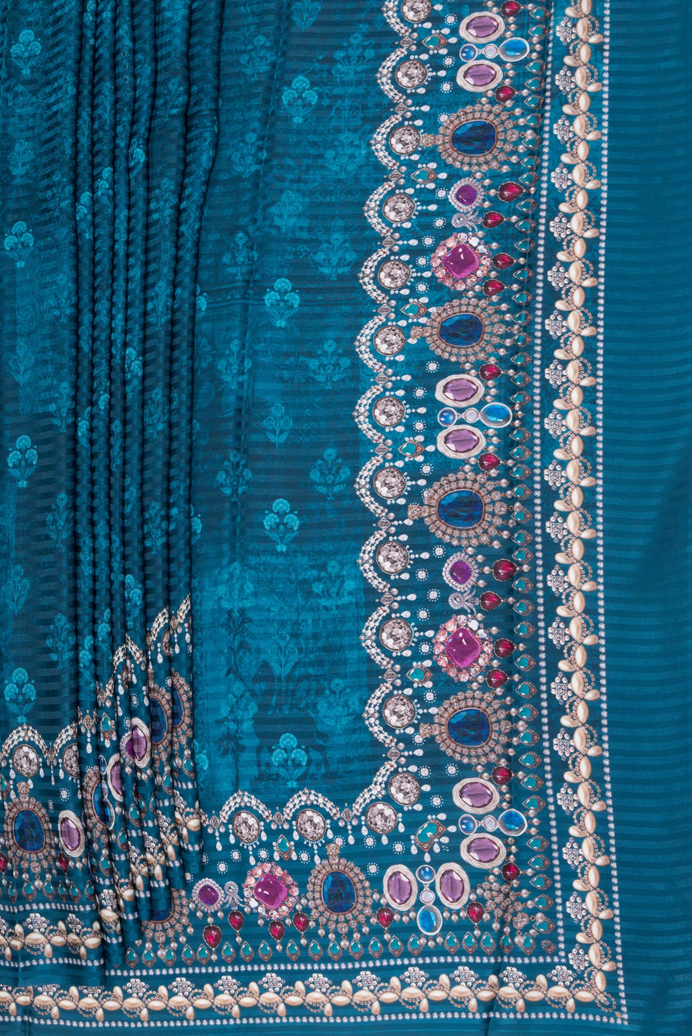 Pleats and pallu of Peacock Blue Crepe Saree with Printed design on the body and Printed Border. 