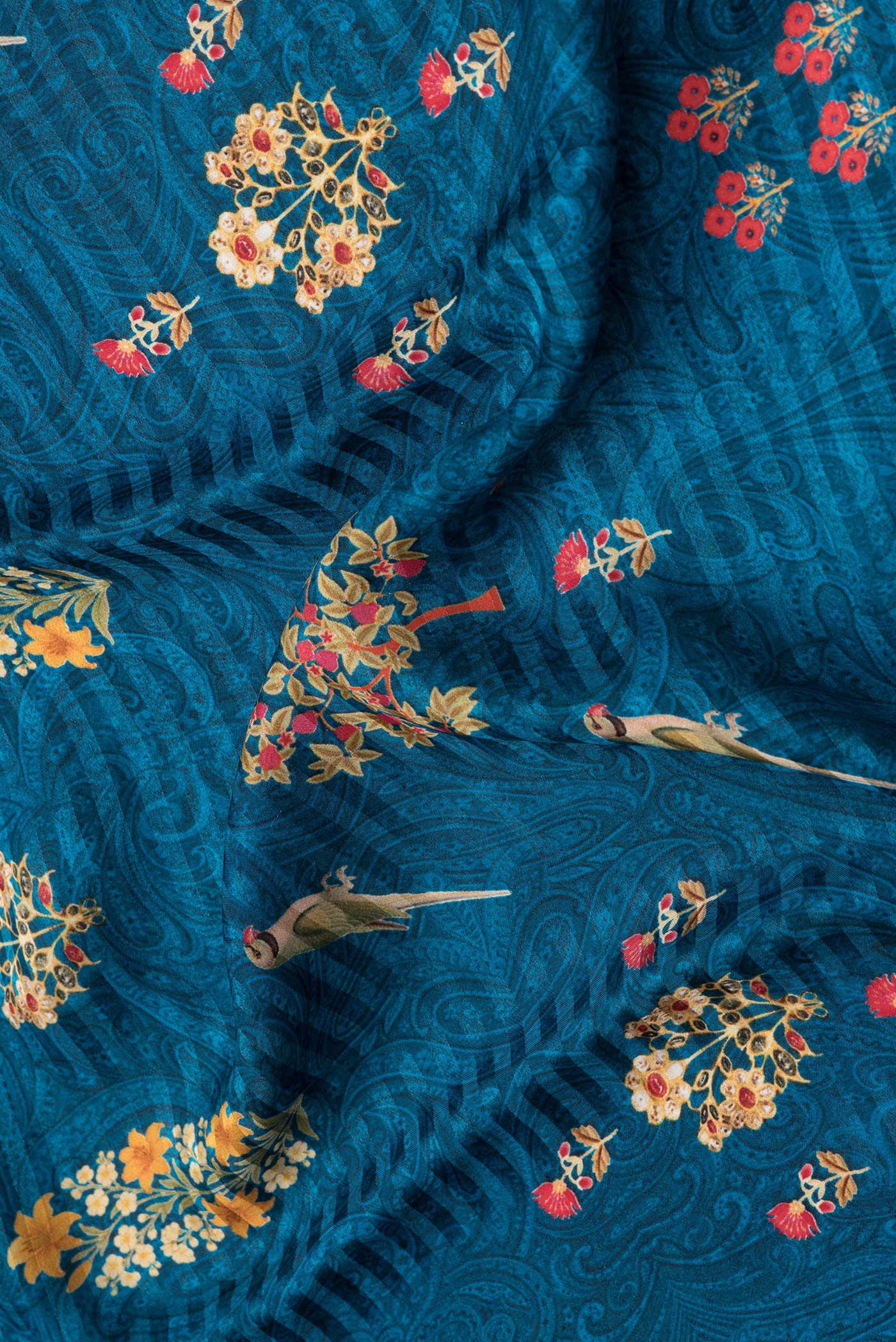 Close up of Peacock Blue Dual Tone Mysore Crepe Saree with Printed design on the body and Printed Border.  displaying folds