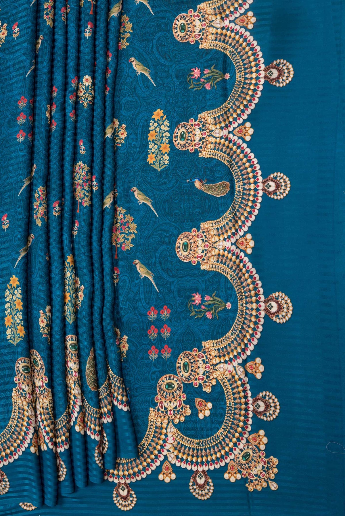 Pleats and pallu of Peacock Blue Dual Tone Mysore Crepe Saree with Printed design on the body and Printed Border. 