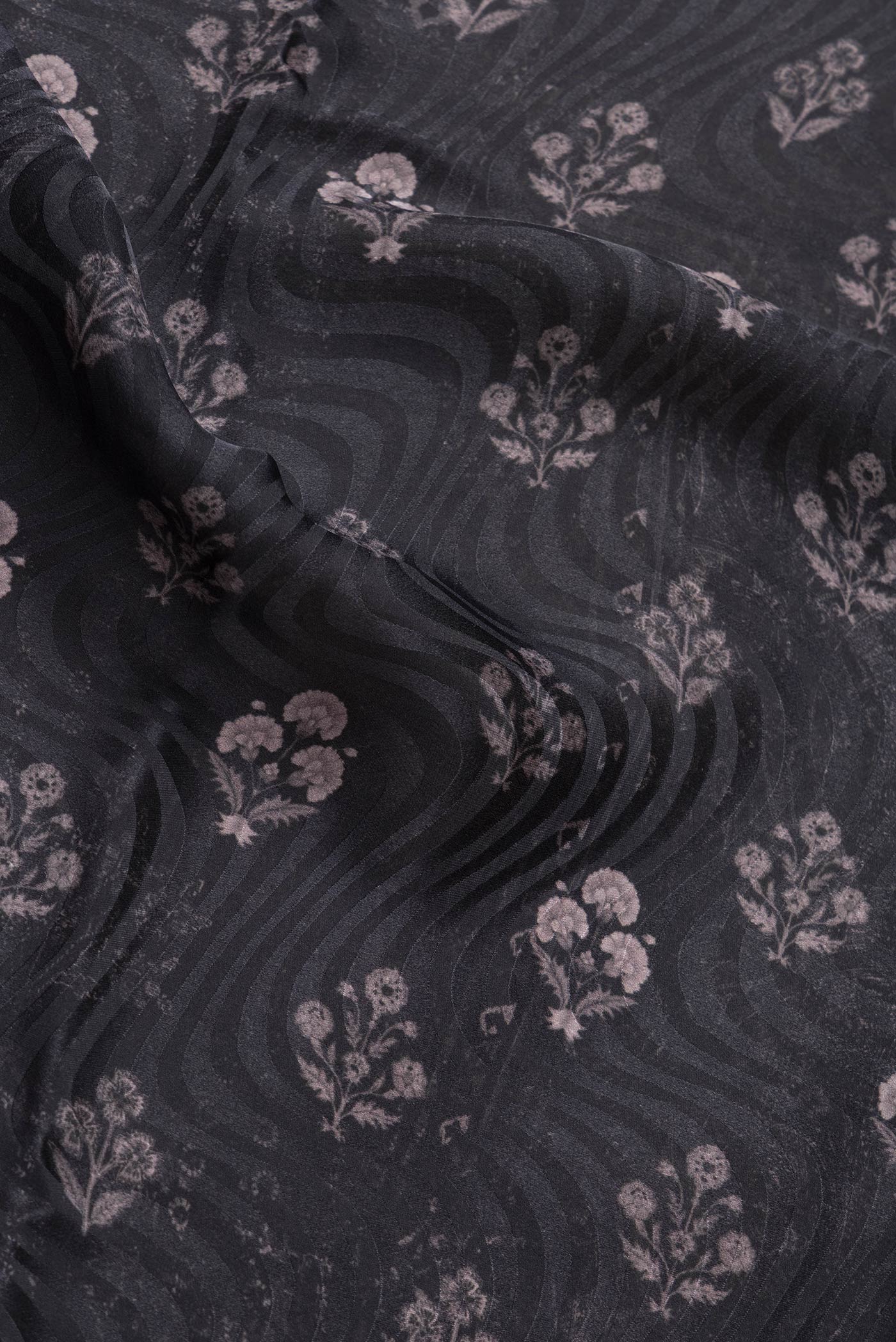 Close up of Black Dual Tone Mysore Crepe Saree with Printed design on the body and Printed Border.  displaying folds
