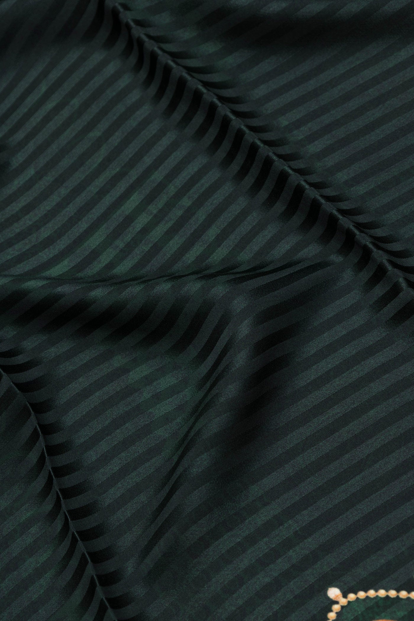 Close up of Bottle Green Dual Tone Mysore Crepe Saree with Printed design on the body and Printed Border.  displaying folds