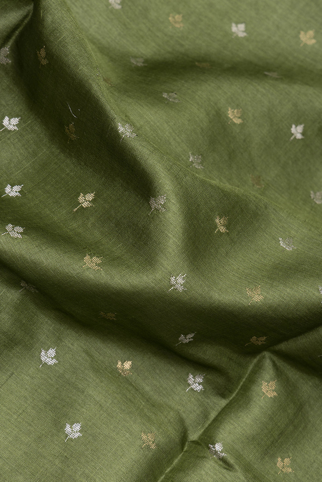 Close up of Mehandi Green Dual Tone Tussar Silk Saree with Zari Butta on the body and Zari Border.  displaying folds